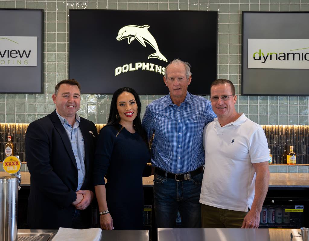 DB Roofing with Wayne Bennett, posing for a photo in front of a Dolphins NRL sign